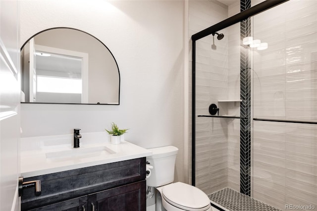 bathroom with a shower with door, vanity, and toilet