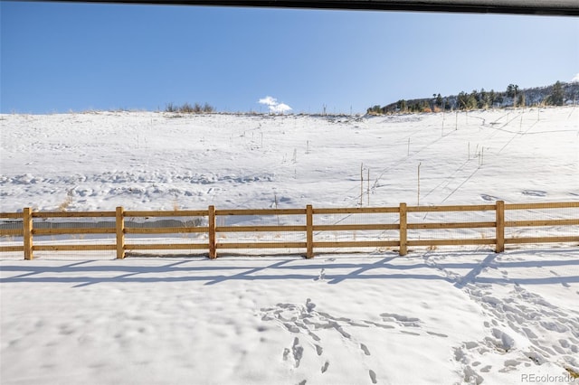 snowy yard with a rural view