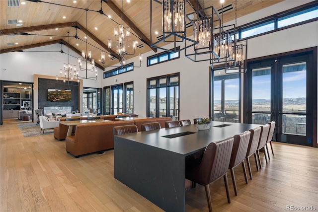 dining area with beamed ceiling, high vaulted ceiling, wooden ceiling, and light wood-type flooring