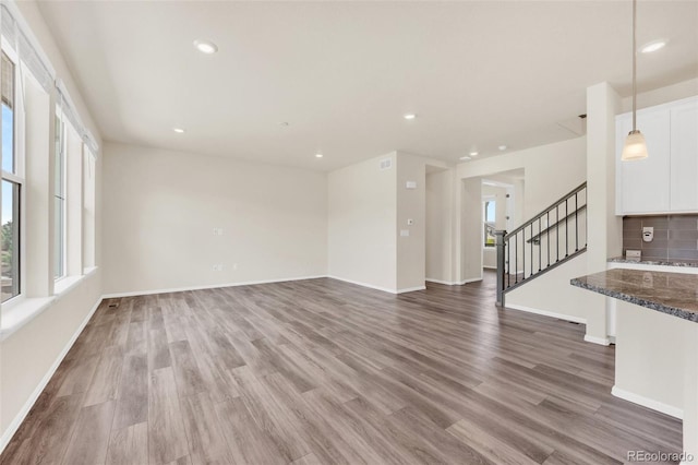 3325 Umber Cir, Castle Rock, CO 80109 - unfurnished living room featuring wood finished floors, stairway, baseboards, and recessed lighting