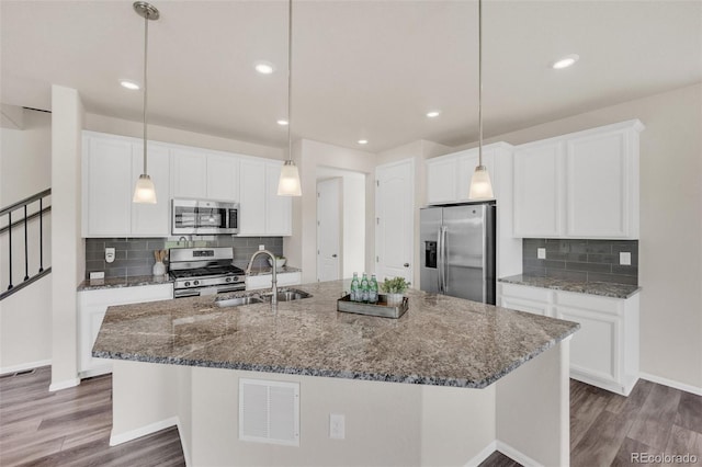 3325 Umber Cir, Castle Rock, CO 80109 - kitchen featuring stainless steel appliances, a sink, wood finished floors, an island with sink, and recessed lighting