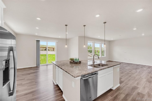 3325 Umber Cir, Castle Rock, CO 80109 - kitchen featuring stainless steel appliances, a sink, open floor plan, plenty of natural light, and recessed lighting