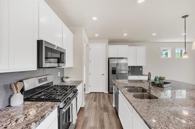3325 Umber Cir, Castle Rock, CO 80109 - kitchen with appliances with stainless steel finishes, a sink, light wood-style flooring, white cabinets, and light stone countertops