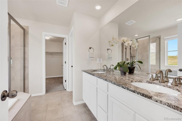 3325 Umber Cir, Castle Rock, CO 80109 - bathroom featuring a shower stall, double vanity, a spacious closet, tile patterned floors, and baseboards