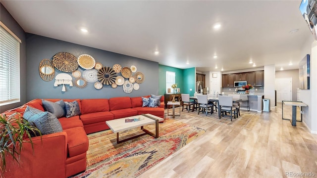 living area with recessed lighting, light wood-type flooring, and baseboards