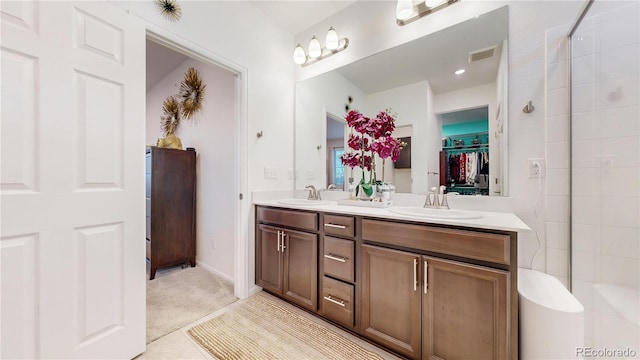 full bath featuring double vanity, visible vents, a spacious closet, and a sink