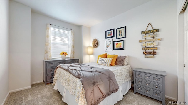 bedroom featuring baseboards and light colored carpet