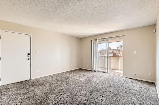 carpeted spare room with a textured ceiling and baseboards