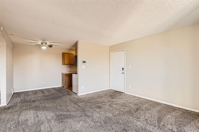 unfurnished living room with baseboards, a textured ceiling, dark carpet, and a ceiling fan