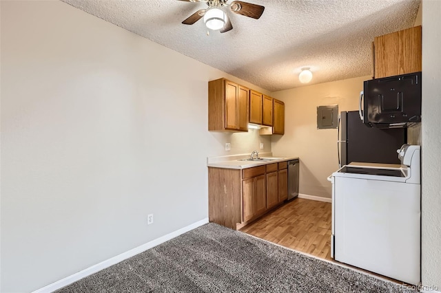 kitchen with brown cabinetry, black microwave, range, and a sink