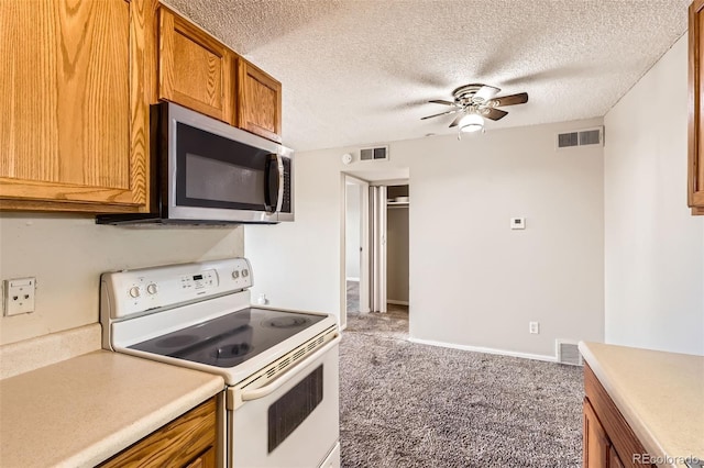 kitchen featuring visible vents, stainless steel microwave, and white electric range