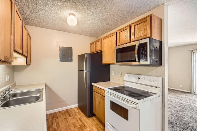 kitchen with a textured ceiling, a sink, light countertops, appliances with stainless steel finishes, and electric panel