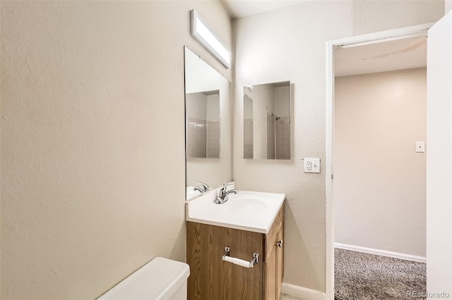 bathroom with toilet, baseboards, and vanity