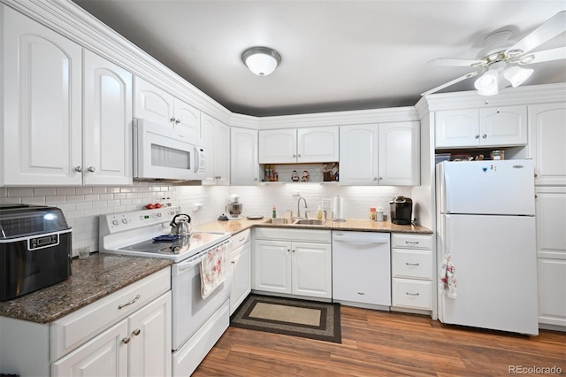 kitchen with white appliances, dark wood-style flooring, a sink, white cabinetry, and decorative backsplash