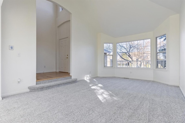 unfurnished living room featuring carpet floors and lofted ceiling