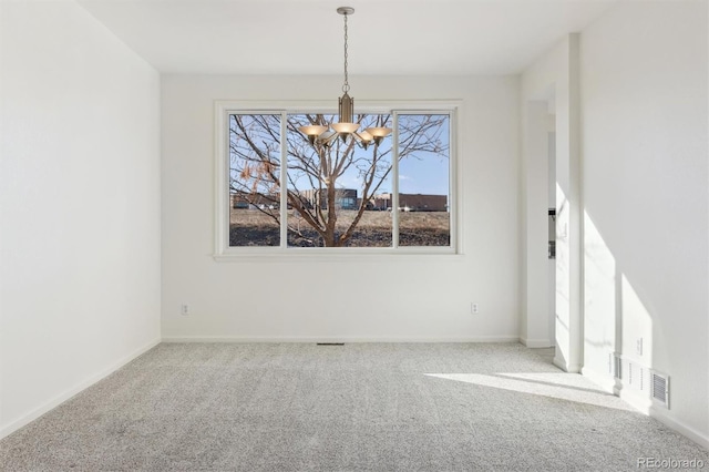 empty room featuring carpet and a chandelier