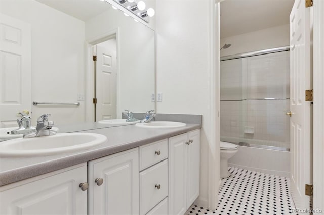 full bathroom with tile patterned floors, vanity, enclosed tub / shower combo, and toilet