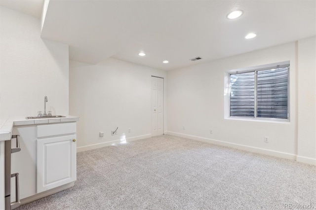 carpeted spare room with indoor wet bar