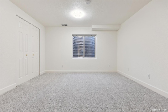 unfurnished bedroom featuring carpet, a textured ceiling, and a closet