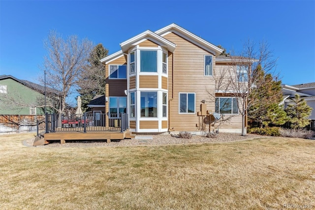 rear view of house with a lawn and a deck