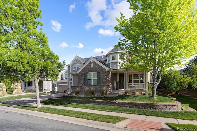 6040 Virgil St, Arvada, CO 80403 - view of front of home featuring brick siding, asphalt driveway, covered porch, a front lawn, and a garage