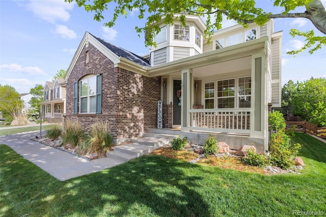 6040 Virgil St, Arvada, CO 80403 - view of front of property with brick siding, a front yard, and a porch