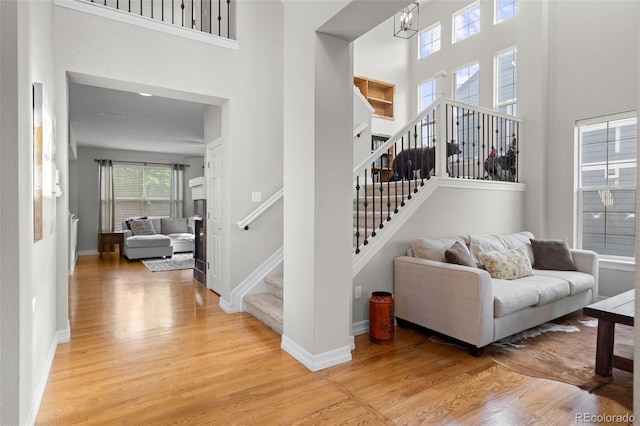 6040 Virgil St, Arvada, CO 80403 - entryway featuring a towering ceiling, light wood-style flooring, stairs, and baseboards