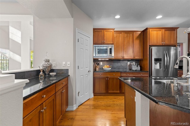 6040 Virgil St, Arvada, CO 80403 - kitchen with stainless steel appliances, light wood-style floors, backsplash, brown cabinets, and recessed lighting
