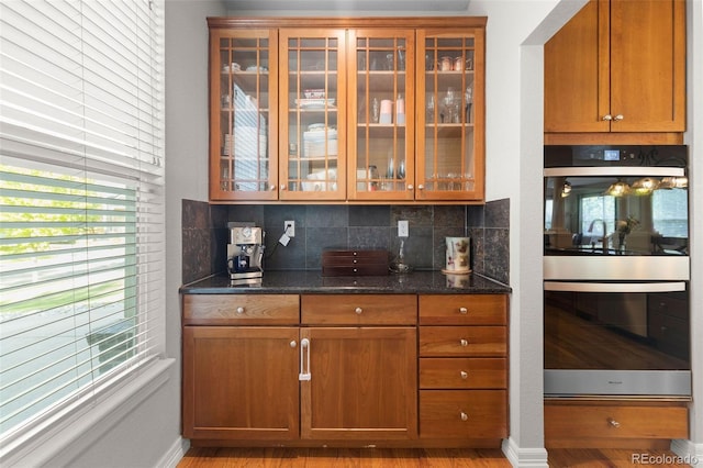 6040 Virgil St, Arvada, CO 80403 - bar area featuring double oven, tasteful backsplash, light wood finished floors, and baseboards