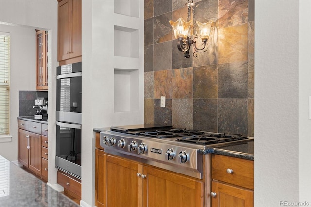 6040 Virgil St, Arvada, CO 80403 - kitchen with stainless steel appliances, a chandelier, backsplash, dark countertops, and brown cabinets
