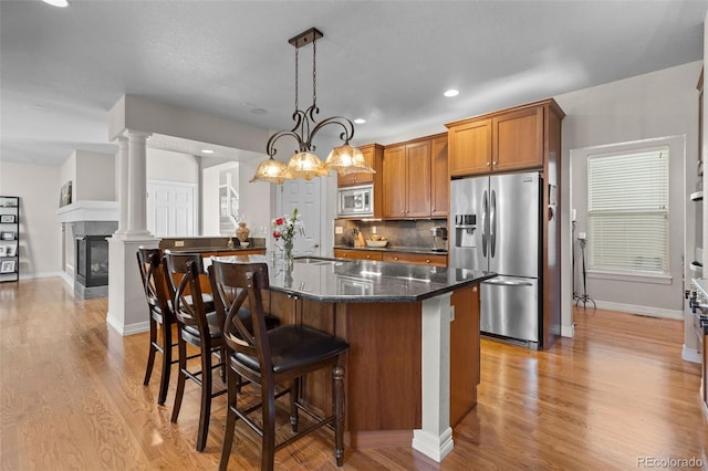6040 Virgil St, Arvada, CO 80403 - kitchen featuring appliances with stainless steel finishes, a breakfast bar, light wood-style floors, a sink, and recessed lighting