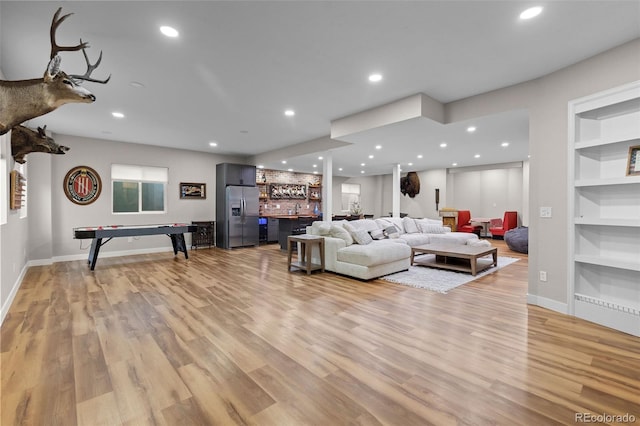 6040 Virgil St, Arvada, CO 80403 - living room featuring bar with sink, light wood-style floors, recessed lighting, baseboards, and built in shelves