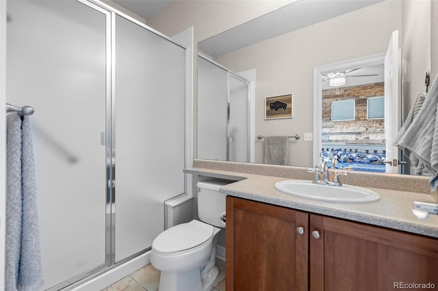 6040 Virgil St, Arvada, CO 80403 - full bathroom featuring a stall shower, toilet, vanity, ceiling fan, and tile patterned floors