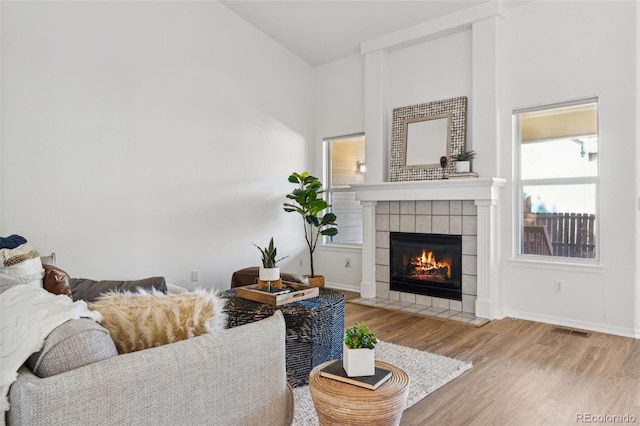 living room featuring hardwood / wood-style flooring and a tile fireplace