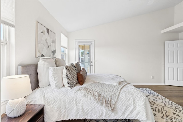 bedroom with vaulted ceiling and dark hardwood / wood-style floors