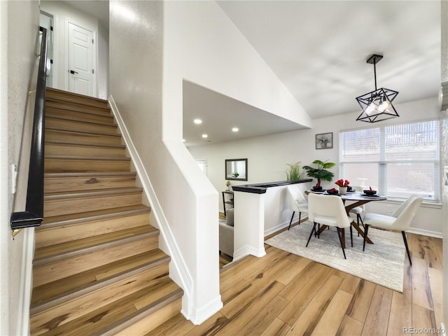 dining room featuring vaulted ceiling and light hardwood / wood-style flooring