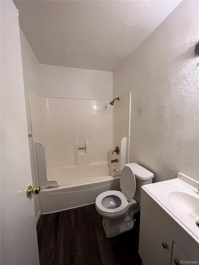 full bathroom with hardwood / wood-style floors, vanity, toilet, and  shower combination