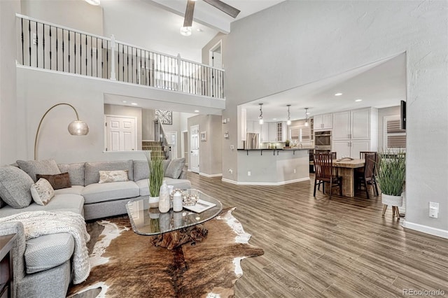 living room featuring high vaulted ceiling, hardwood / wood-style flooring, and beam ceiling