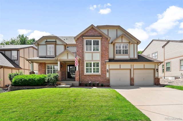 tudor-style house featuring a garage and a front yard