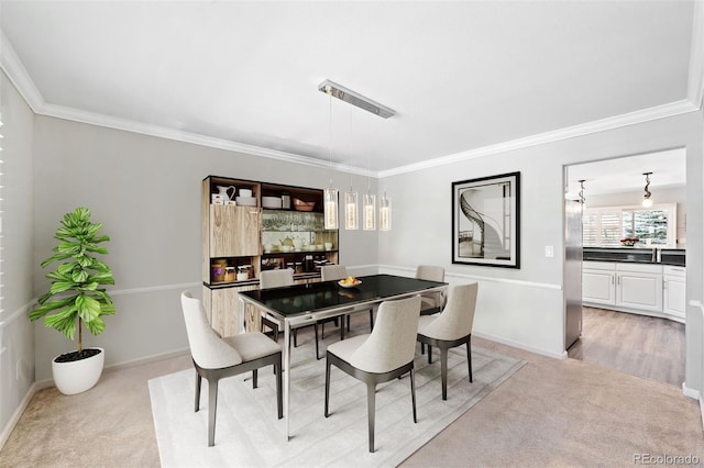 dining area with light colored carpet and ornamental molding