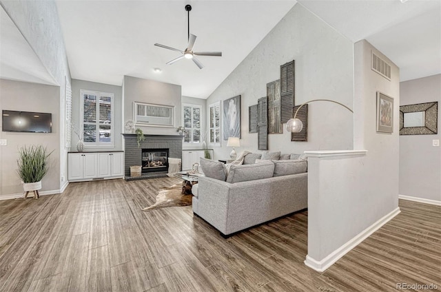 living room featuring hardwood / wood-style floors, a wealth of natural light, ceiling fan, and a fireplace