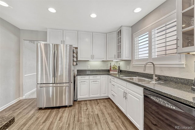 kitchen with white cabinetry, stainless steel refrigerator, sink, dishwasher, and light hardwood / wood-style flooring