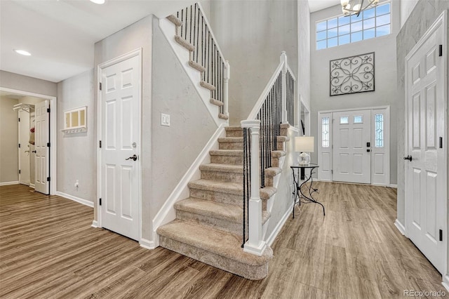 entrance foyer featuring hardwood / wood-style flooring, a high ceiling, and a chandelier