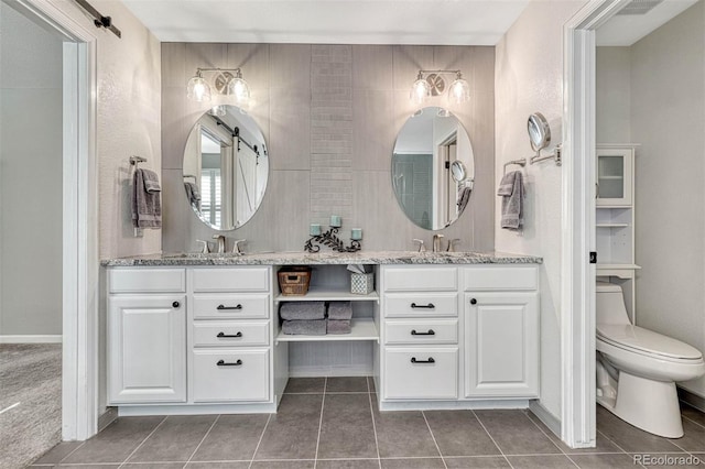 bathroom featuring toilet, vanity, and tile patterned flooring