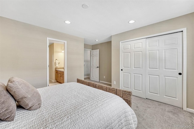 carpeted bedroom with a closet and ensuite bathroom