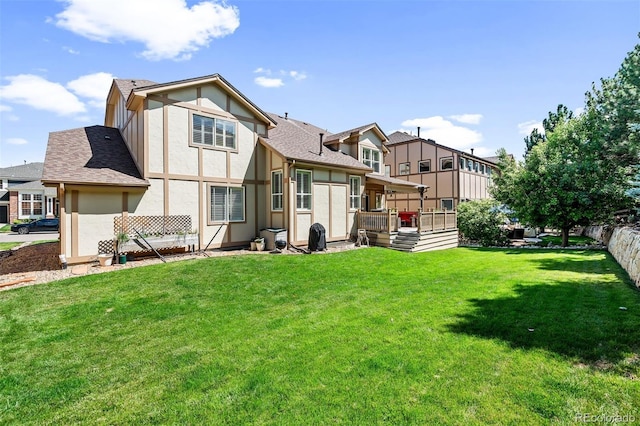 rear view of house featuring a deck and a yard