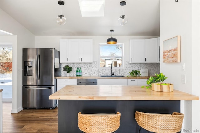 kitchen with white cabinetry, appliances with stainless steel finishes, sink, and butcher block countertops