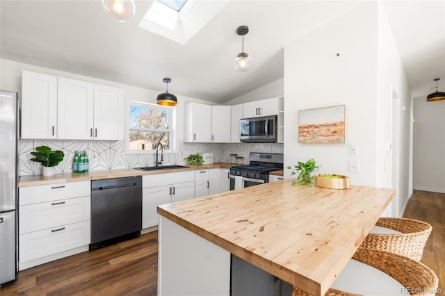 kitchen with pendant lighting, white cabinetry, appliances with stainless steel finishes, and sink