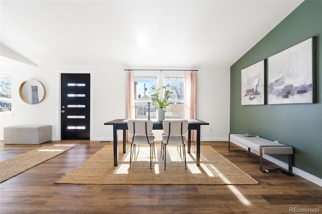 dining area featuring lofted ceiling and dark wood-type flooring