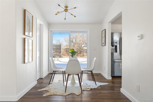 dining area with dark hardwood / wood-style flooring and a notable chandelier